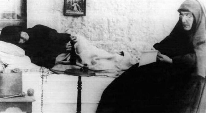 Santa Rafqa postrada en cama en Jrabta, atendida por una hermana, en los últimos años de su vida.
